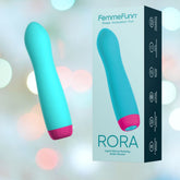 A turquoise liquid silicone fully rotating bullet vibrator with a magenta base stands next to its matching box labeled "Femme Funn Rora Rotating Bullet Vibrator - Turquoise." The box features product information, highlighting its 8 vibration modes, and displays the same image of the Femme Funn Rora Rotating Bullet Vibrator on the front. The background is a soft bokeh effect.